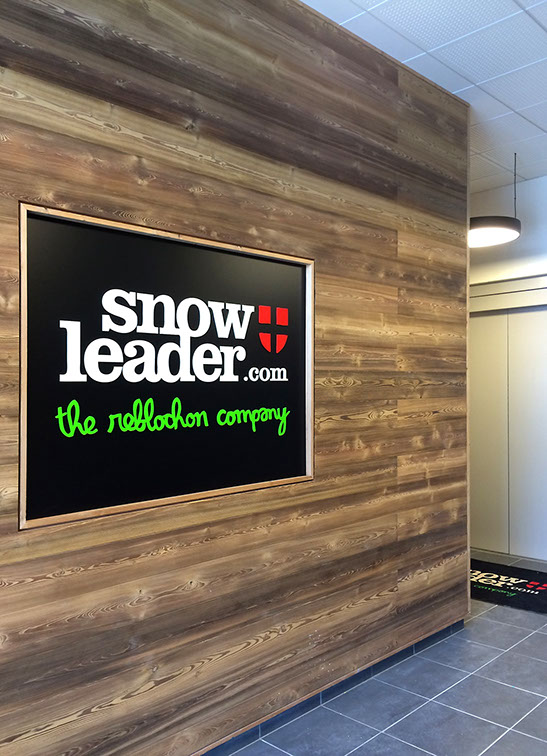 Hall d'entrée du bâtiment. Finition des murs en bardage chêne rétifié et incustation du logo Snowleader.